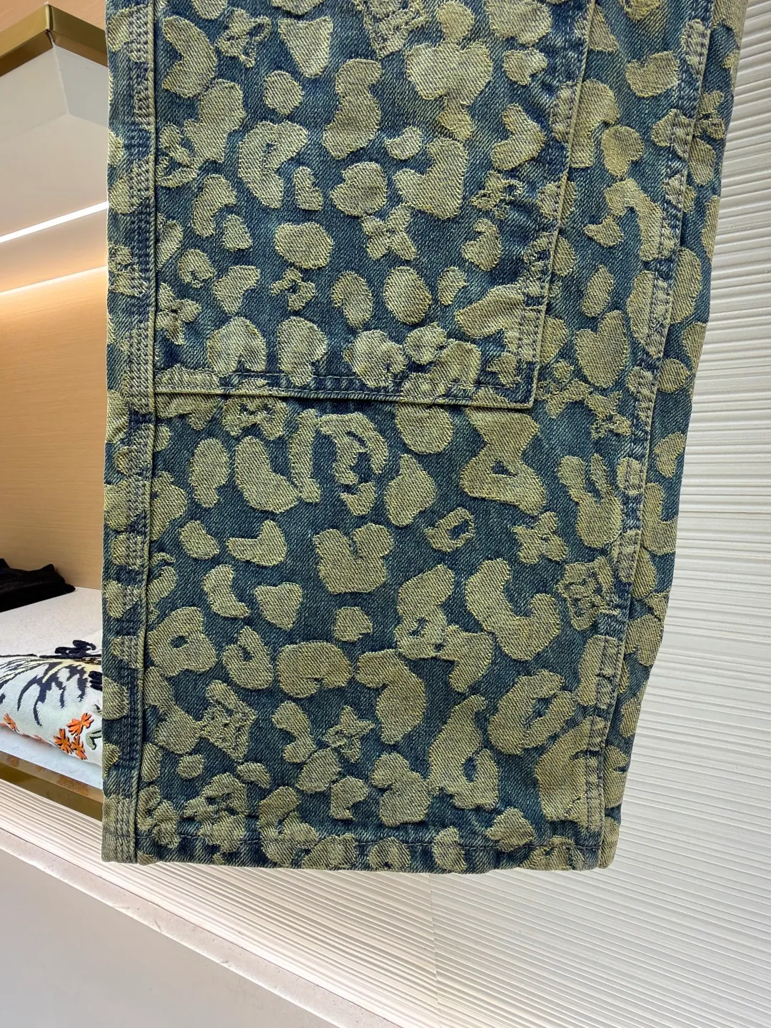 LOUIS VUITTON letter jacquard pearl buckle work denim trousers ●Original version: Purchased and developed by 14099 ●Item number: 1682239-B85 ●Material: denim fabric ●Technology: jacquard production ●Version: fitted version ●Weight: about 905 grams ●Size: 28-30-32-34-36 ●Description: These printed jeans are made of 12-ounce heavyweight denim. They are treated with enzyme washing and stone grinding. The fabric is soft and retains a crisp texture, while forming a natural distressed texture. The camouflage printing on the trousers adopts digital direct injection technology, and the ink penetrates into the yarn. The pattern color is firm, layered and not easy to crack and fall off. The shape is a loose straight cut, using three-dimensional cutting technology to fit ergonomics, and the crotch is reinforced with classic horsetail technology to improve wearing comfort and durability. The waistband is equipped with custom-made metal buttons and I-buckles, which have been treated with anti-oxidation plating and have a thick texture. The edges of the pockets are made of double-lane stitching, with fine and even stitching. The side seams and inseam are all hemmed, and every stitching is tightly stitched. The exquisite trousers-making craftsmanship and quality control are demonstrated in every detail. The overall wiring is straight and delicate, the fabric is comfortable and soft, and the color is consistent without color difference. It can be matched with the same style to create a fashionable look and control various occasions. Customized accessories, complete with three standards, same style for men and women!